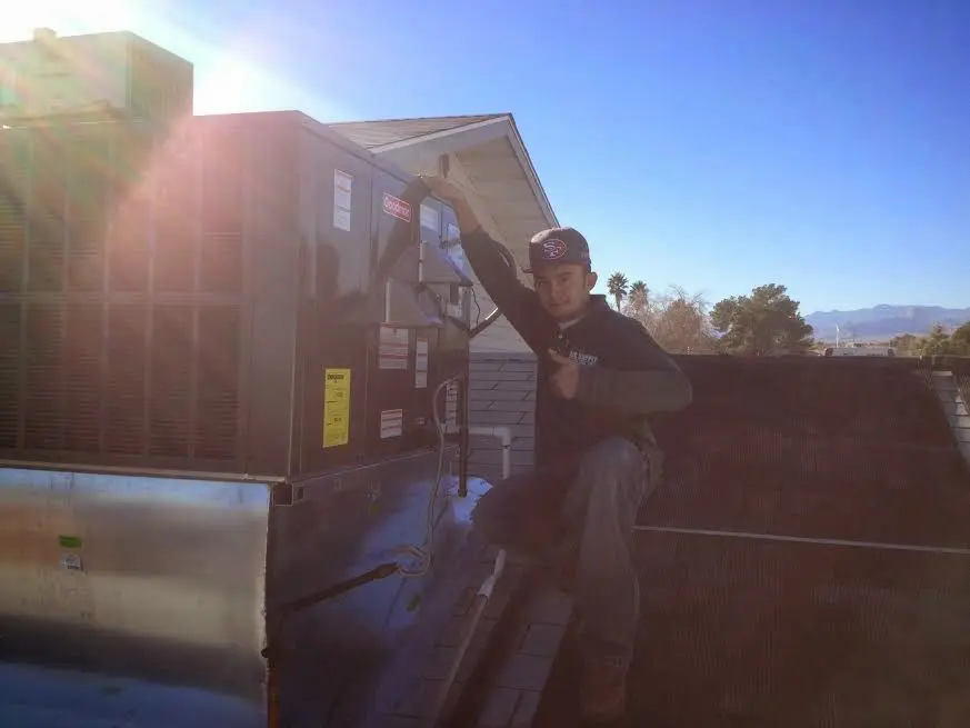 HVAC technician performing Boiler Repair on a rooftop unit in Chackbay